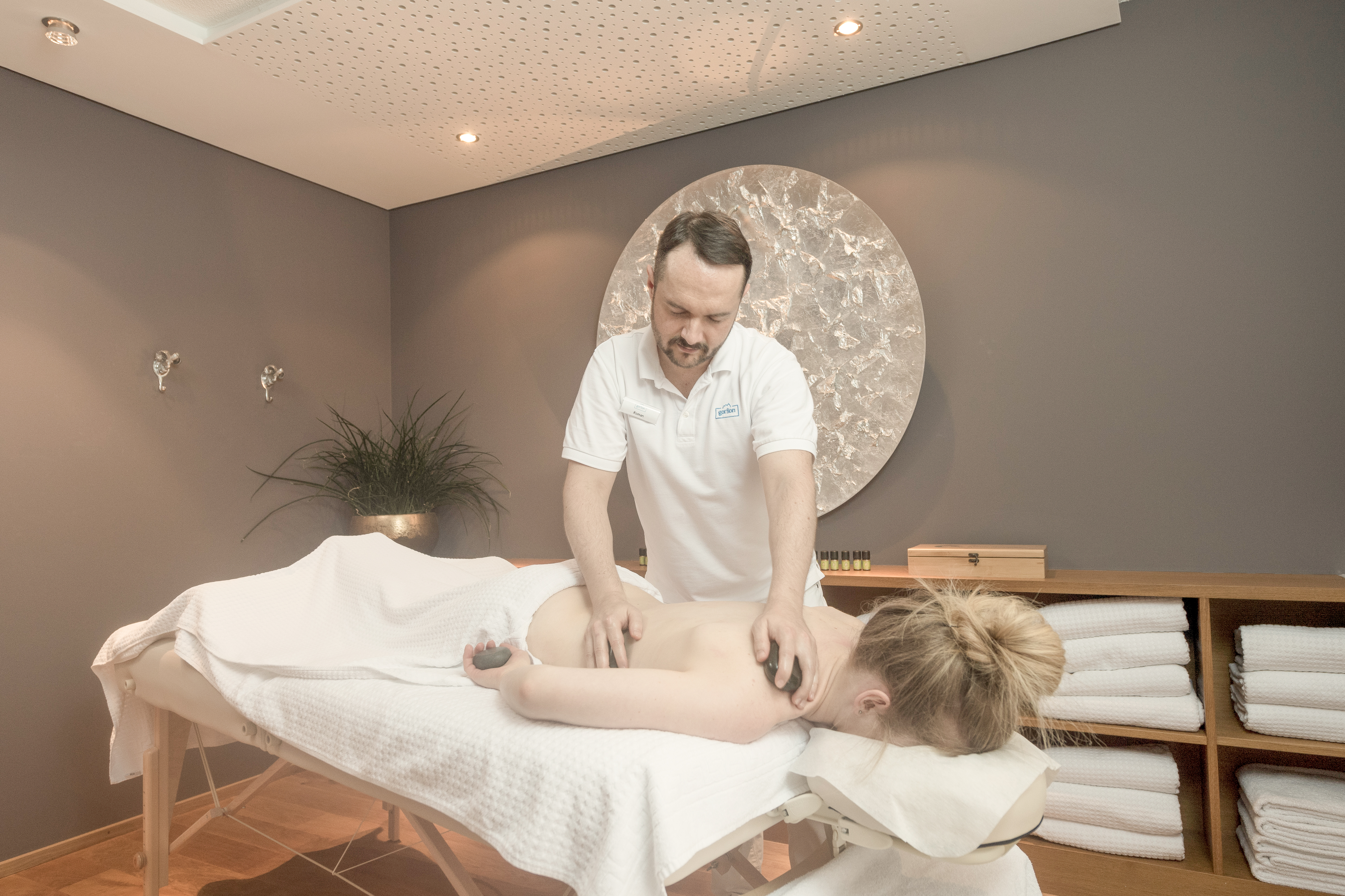 Hotel-fuer-Allergiker: BergWellness 1600
Zwischen Kinderprogramm, Poolaction und Abendessen passt oft genau eine Sache gut hinein: eine Massage, eine Behandlung, ein Moment nur für euch. Genau dafür ist das BergWellness 1600 da. In unserem Spa in Liechtenstein geht es um Berührung, Pflege und bewusste Zeit zum Abschalten. Massagen lösen Verspannungen, Kosmetikbehandlungen schenken frische Impulse, wohltuende Rituale geben dem Urlaubstag eine neue Richtung. Sanfte Musik und feine Duftwelten begleiten jede Anwendung, damit ihr euch mause-wohl fühlt. Zur Pflege eurer Haut arbeiten wir mit nachhaltigen Produkten. Die machen nicht nur eine mause-weiche Haut, sondern sind auch gut zu unserer Natur. - Gorfion Familienhotel Liechtenstein